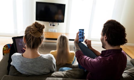 Friends in the living room, using digital devices